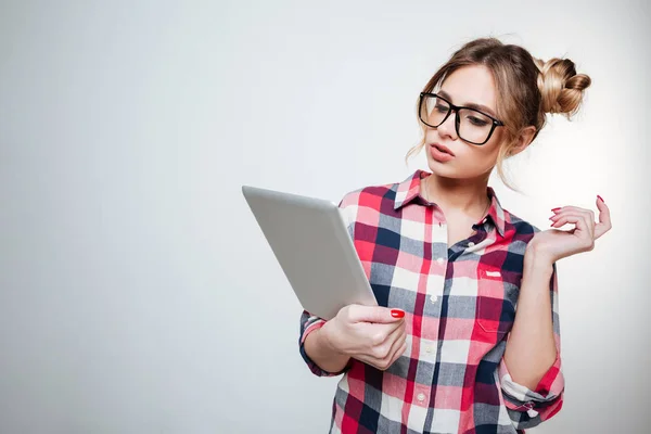 Woman in shirt and eyeglasses using tablet computer