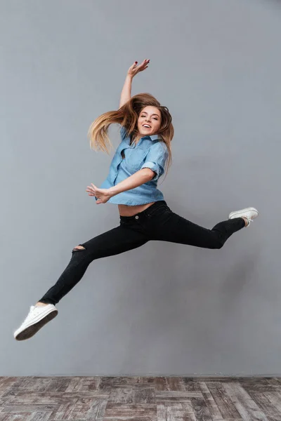 Imagen completa de la mujer en camisa saltando en el estudio — Foto de Stock