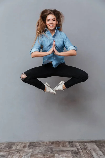 Portrait complet de femme en chemise sautant en studio — Photo