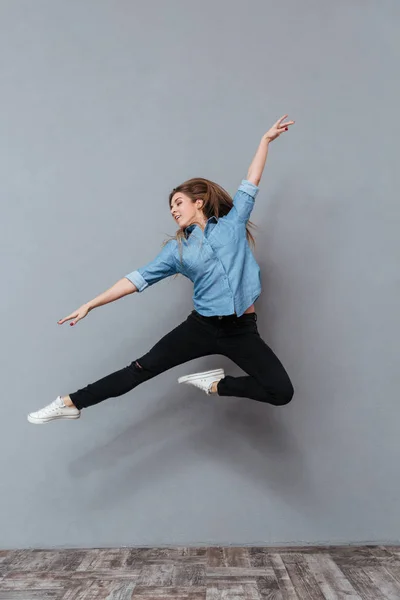 Retrato completo de mujer en camisa saltando en el estudio — Foto de Stock