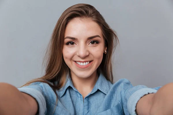 Usmívající se žena v košili, takže selfie ve studiu — Stock fotografie