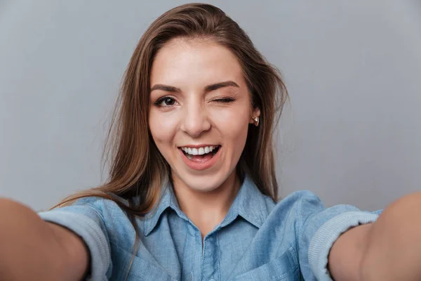 Sorridente Donna in camicia facendo selfie in studio e ammicca — Foto Stock