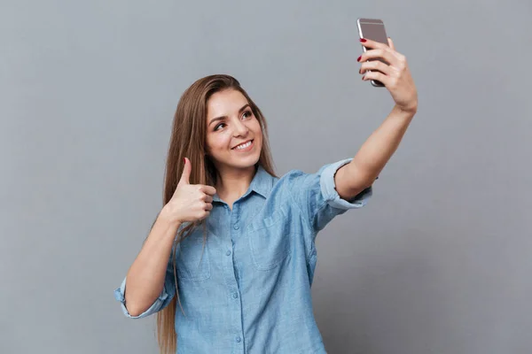 Jovem mulher em camisa fazendo selfie no smartphone — Fotografia de Stock