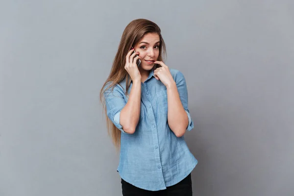 Mulher tímida na camisa falando no telefone — Fotografia de Stock