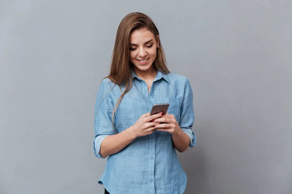 Lachende vrouw in hemd met behulp van de telefoon — Stockfoto