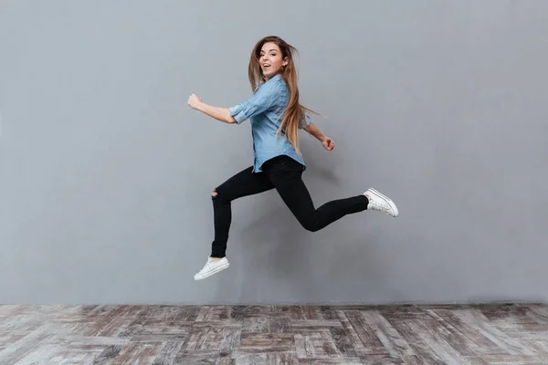 Imagem de comprimento total de Funny Woman jumping em estúdio — Fotografia de Stock