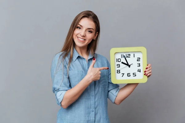 Sorridente donna in camicia che tiene orologio — Foto Stock