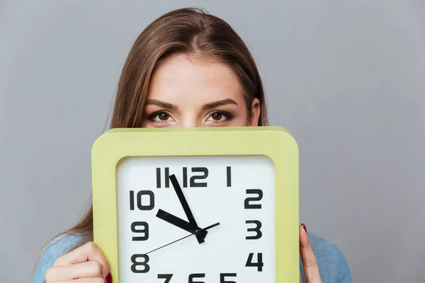 Frau im Hemd versteckt sich hinter der Uhr — Stockfoto