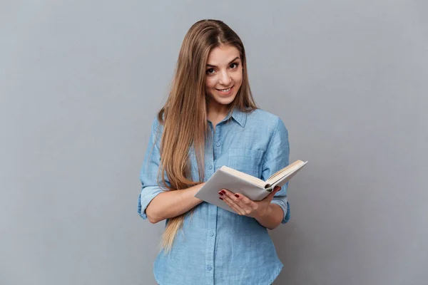 Женщина в футболке читает книгу — стоковое фото