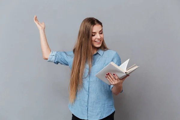 Uśmiechnięta kobieta recytuje z książką w ręku — Zdjęcie stockowe