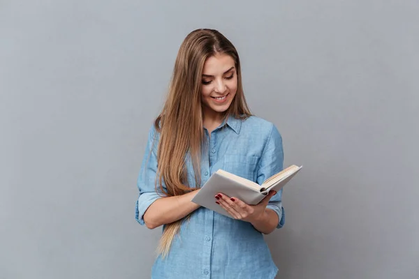 Χαμογελαστή γυναίκα στο πουκάμισο ανάγνωση του βιβλίου — Φωτογραφία Αρχείου
