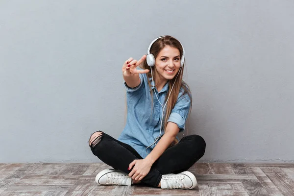 Lachende vrouw luisteren muziek op de verdieping — Stockfoto