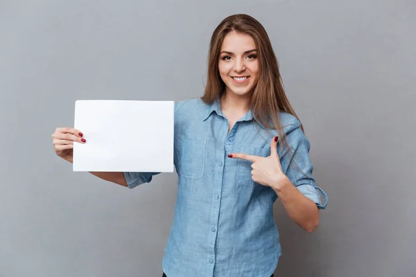 Kvinna i skjorta pekar tomt ombord — Stockfoto