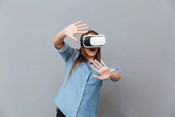 Happy Woman in shirt using virtual reality device