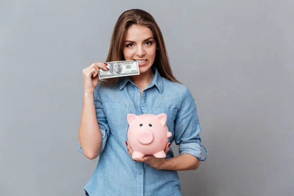 Mujer con camisa sosteniendo una caja de dinero y dinero en las manos — Foto de Stock