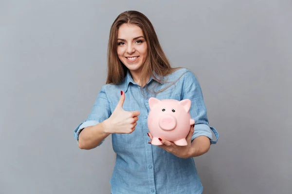 Mujer sonriente en camisa sosteniendo el dinero en la mano — Foto de Stock