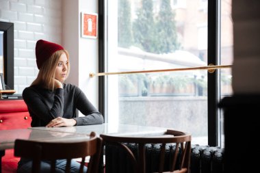 Kırmızı şapkalı kadın dalgın