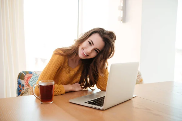 Portret van een jonge vrouw die op laptop thuis werkt — Stockfoto