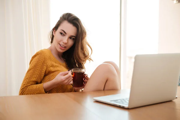 Frau sitzt mit Tasse Tee am Tisch — Stockfoto