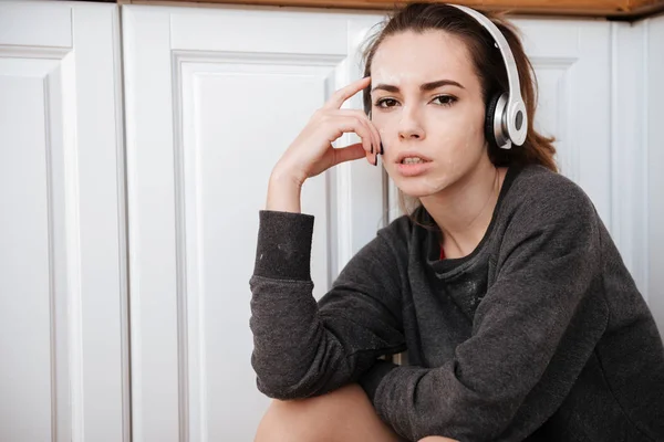 Retrato de una niña triste escuchando música con auriculares —  Fotos de Stock