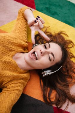 Genç güzel kız göz kırpıyor ve müzik keyfi kulaklık