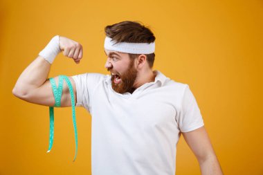 Mutlu genç fitness adam onun pazı ölçme