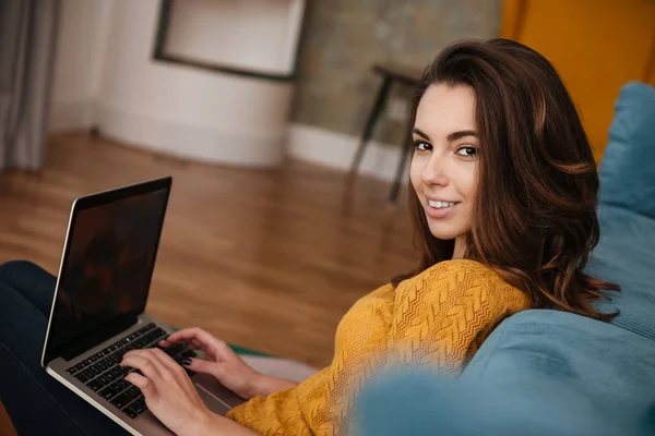 Primer plano retrato de una chica atractiva sonriente usando el ordenador portátil — Foto de Stock