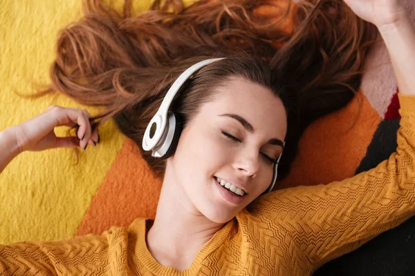 Portrait d'une jeune jolie fille dans un casque jouissant de la musique — Photo