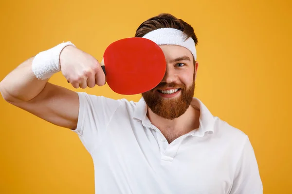 Веселый молодой спортсмен держит ракетку для настольного тенниса . — стоковое фото