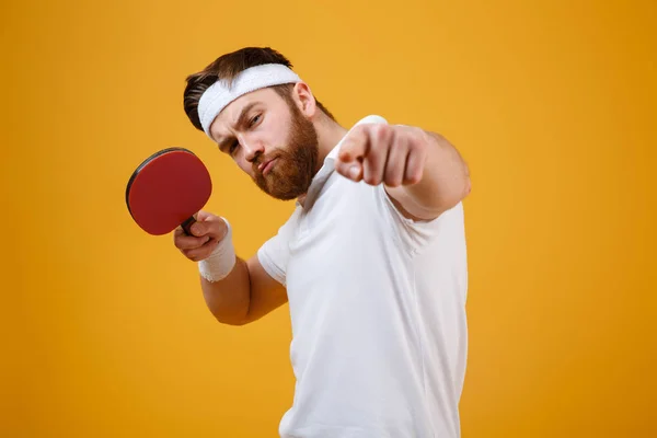 Молодой спортсмен держит ракетку для настольного тенниса, указывая . — стоковое фото