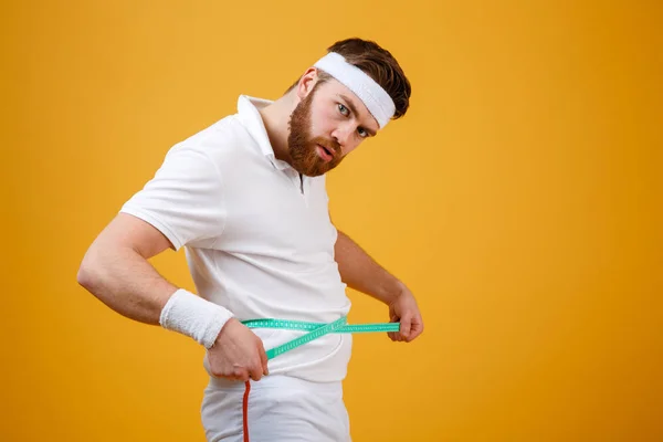 Retrato de un deportista midiendo su cintura con cinta adhesiva —  Fotos de Stock