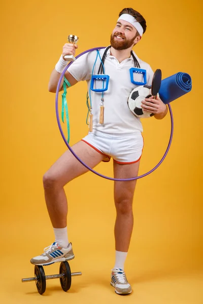 Happy satisfied man champion holding golden cup and sports equipment — Stock Photo, Image