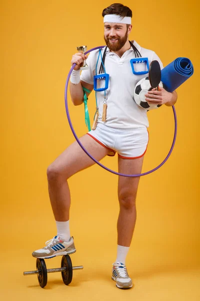 Happy satisfied man champion holding golden cup and sports equipment — Stock Photo, Image