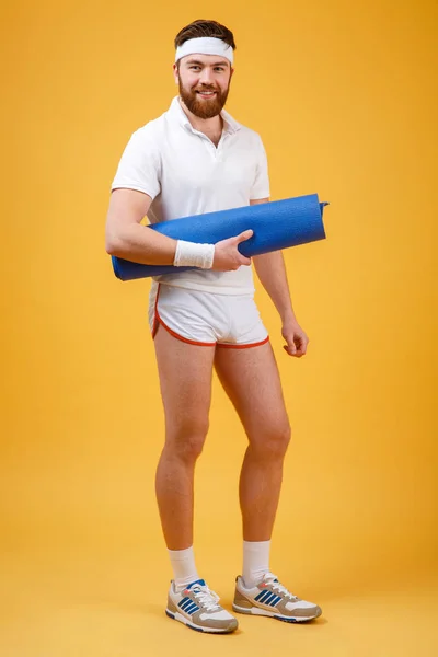 Egy férfi sportoló mat gazdaság teljes hosszúságú portréja — Stock Fotó