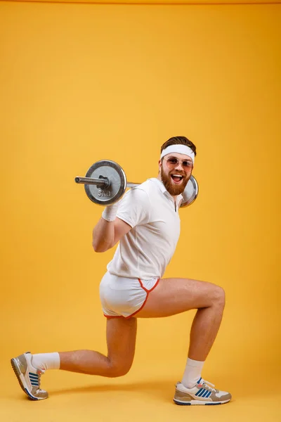 Sidovy av en retro fitness man gör knäböj med skivstång — Stockfoto