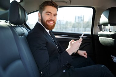 Gülen yan görünüm iş adamı arabada sakallı