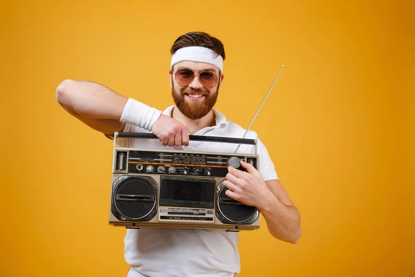 Jovem alegre usando óculos escuros segurando gravador de fita — Fotografia de Stock