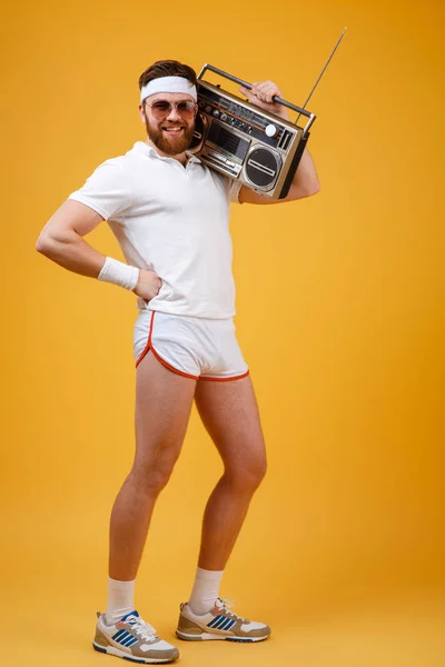 Cheerful young man wearing sunglasses holding tape recorder — Stock Photo, Image