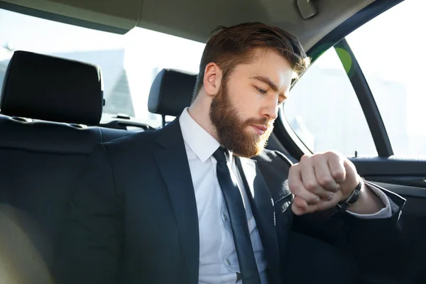 Fiducioso giovane uomo d'affari guardando il suo orologio — Foto Stock