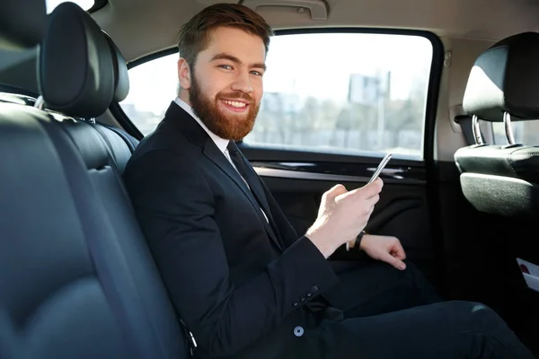 Vista lateral del hombre de negocios barbudo sonriente en coche —  Fotos de Stock