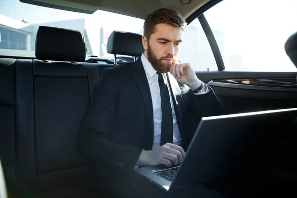 Серьезный бизнесмен с ноутбуком — стоковое фото