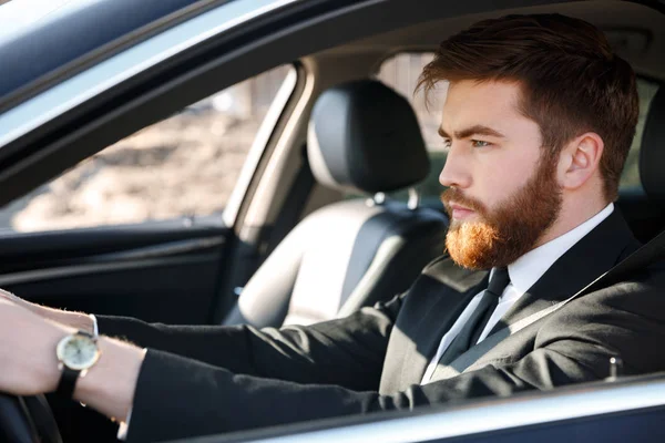 자동차를 운전 하는 심각한 비즈니스 남자의 초상화를 닫습니다 — 스톡 사진