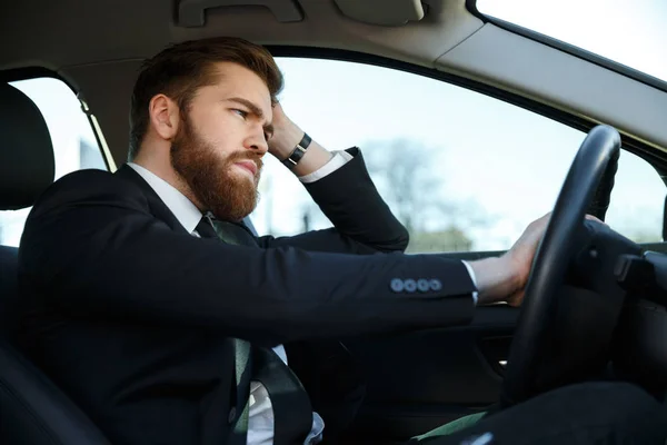 Vista lateral del hombre de negocios cansado conduciendo coche —  Fotos de Stock