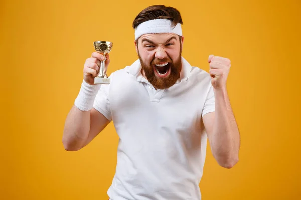 Emocional joven deportista sosteniendo recompensa hacer gesto ganador . — Foto de Stock