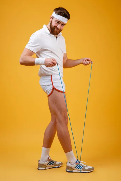 Handsome young sportsman holding skipping rope — Stock Photo, Image