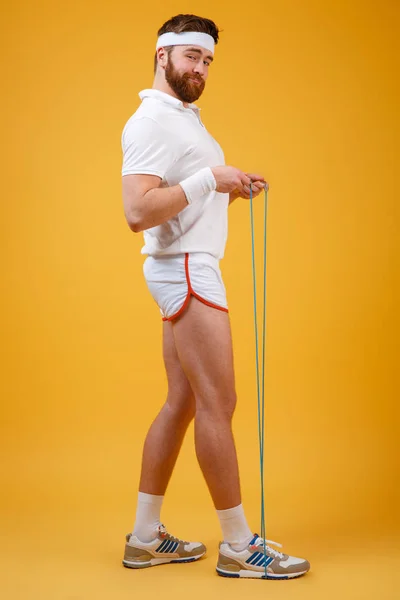 Smiling young sportsman holding skipping rope — Stock Photo, Image