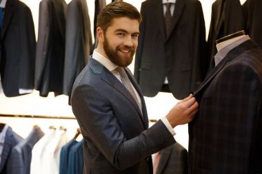 Dükkanda bir ceket seçimi gülümseyen adam yan görünüm