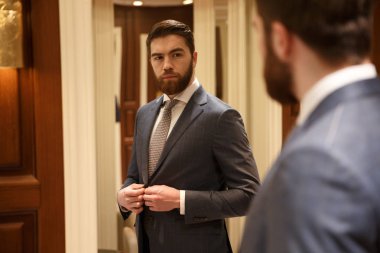 Ciddi adam aynaya bakan arkasında görüntülemek