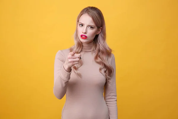 Senhora loira jovem confusa com lábios de maquiagem brilhante apontando — Fotografia de Stock