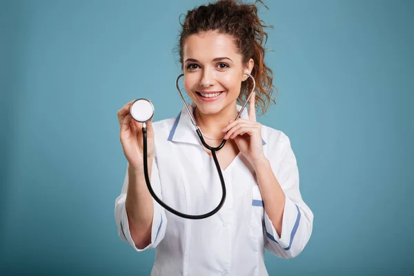 Unga leende kvinnliga läkare håller stetoskop — Stockfoto